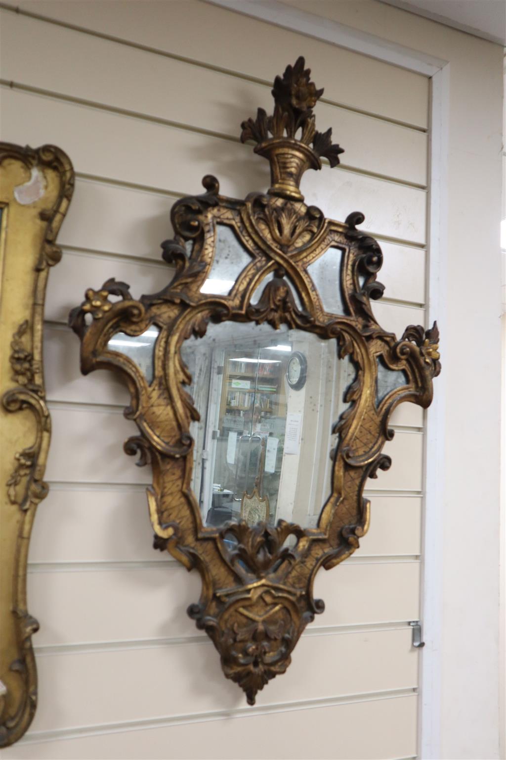 A pair of Italian rococo style carved giltwood wall mirrors, width 56cm, height 88cm
